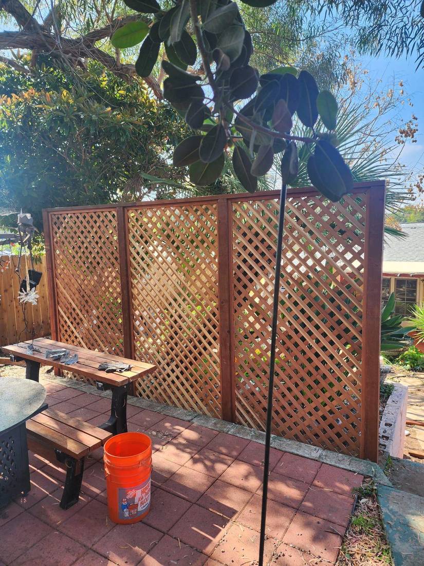 Three-panel wood lattice privacy screen on a San Diego patio — Benitez Tree Service